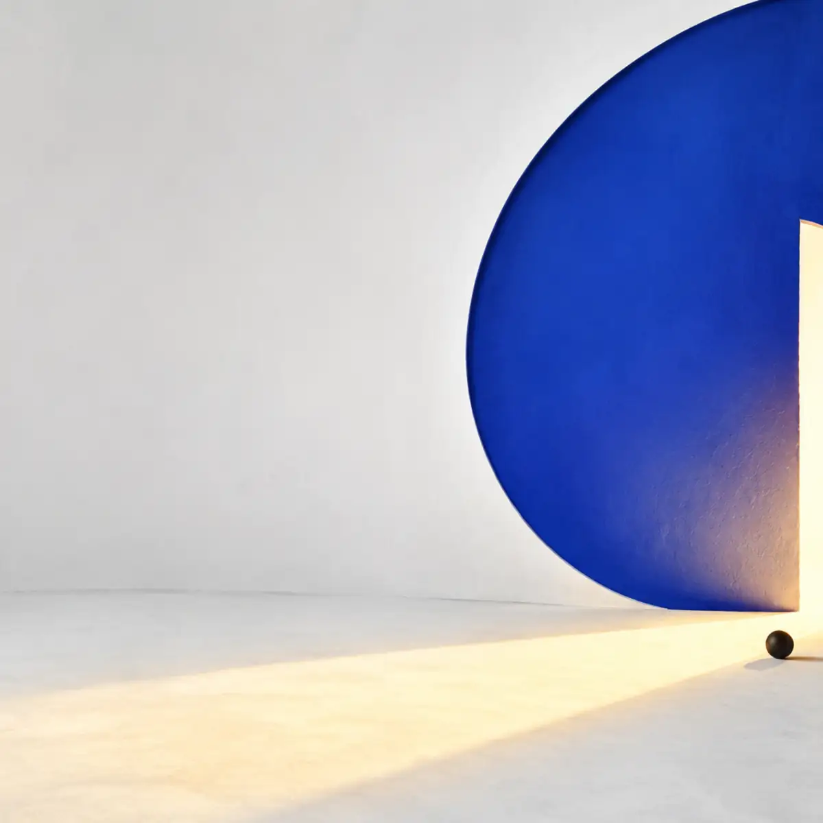 Gran círculo azul descentrado atravesado por una apertura vertical de luz cálida